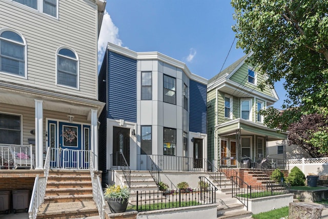 133 W 4th St, Bayonne, NJ 07002 - view of property featuring a porch, a fenced front yard, and stairway