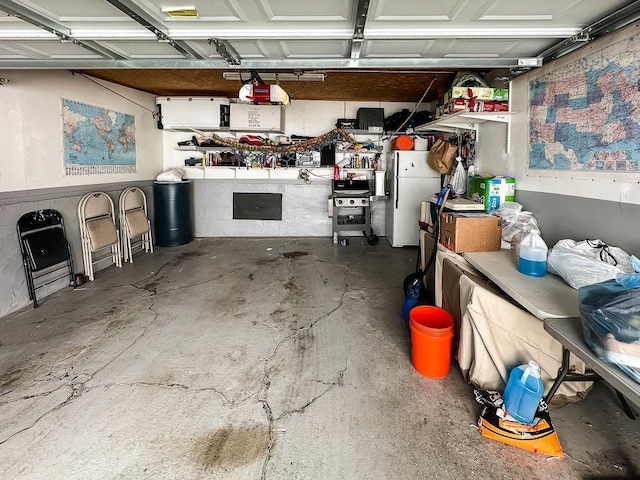 garage featuring a garage door opener and freestanding refrigerator