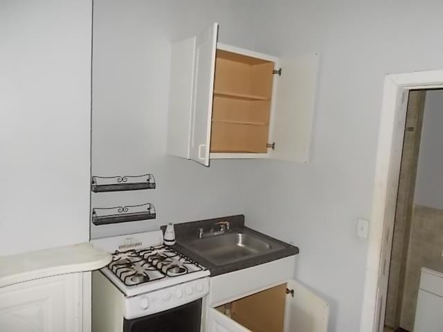 kitchen featuring white cabinetry and white gas stove