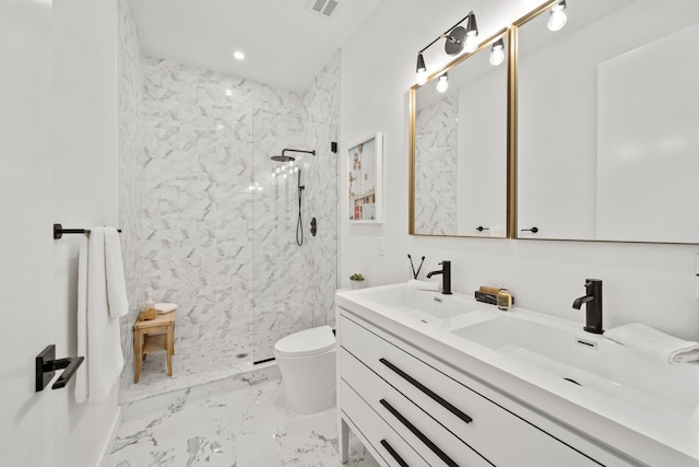 bathroom featuring toilet, vanity, and tiled shower