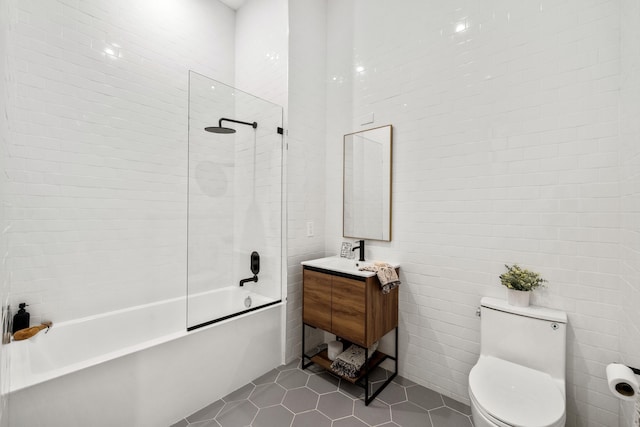 full bathroom with tile patterned floors, tub / shower combination, vanity, tile walls, and toilet