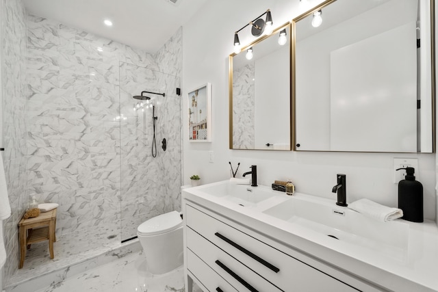 bathroom featuring a tile shower, vanity, and toilet