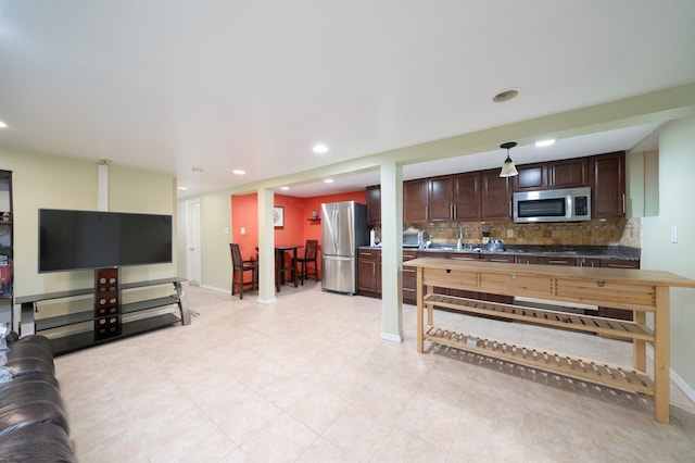 kitchen with decorative backsplash, dark brown cabinets, and stainless steel appliances