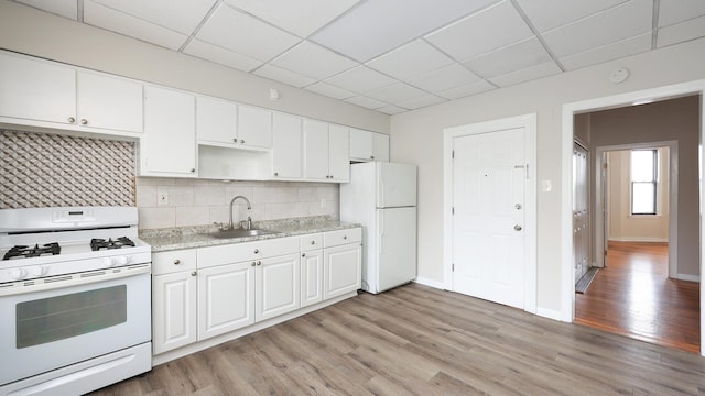 kitchen with light wood-type flooring, white appliances, sink, and white cabinets