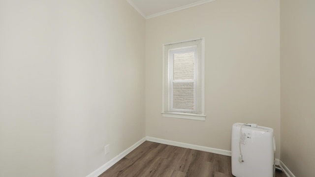 spare room with ornamental molding and dark hardwood / wood-style flooring