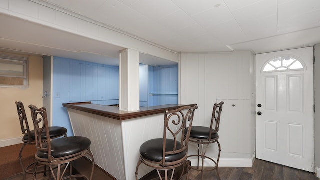 bar featuring dark hardwood / wood-style flooring and wooden walls