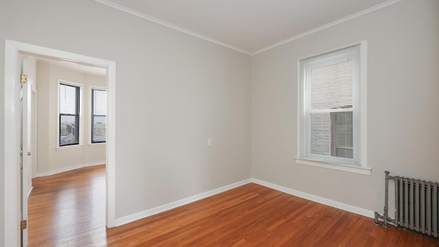 spare room with radiator heating unit, wood-type flooring, and crown molding