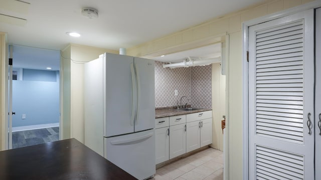 kitchen with white cabinets, sink, white refrigerator, and decorative backsplash