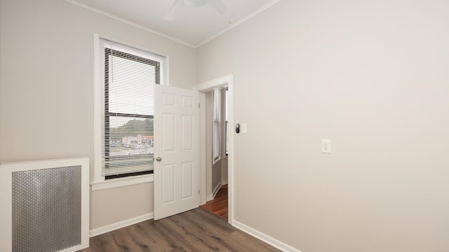 corridor with dark hardwood / wood-style flooring, crown molding, and radiator