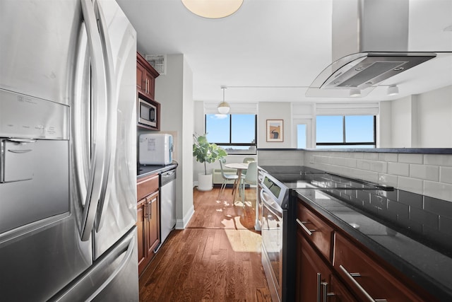 kitchen featuring island range hood, dark wood-style floors, appliances with stainless steel finishes, pendant lighting, and backsplash