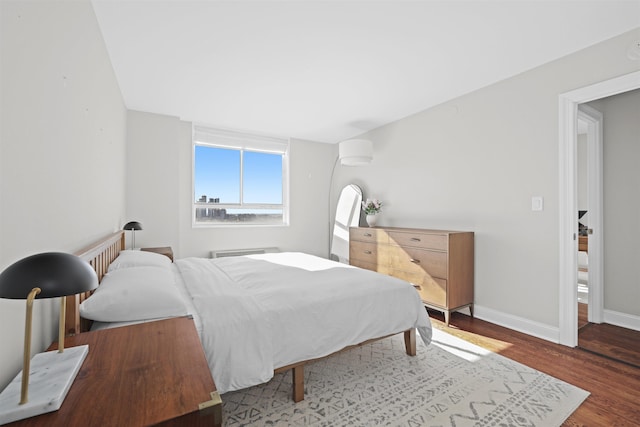 bedroom with baseboards and wood finished floors