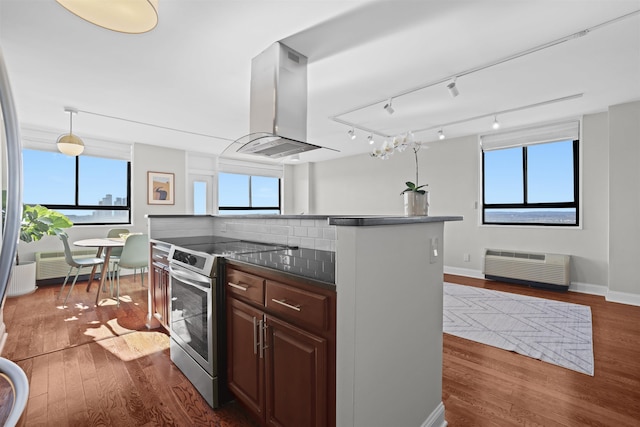 kitchen featuring dark countertops, dark wood-style floors, island range hood, and electric stove