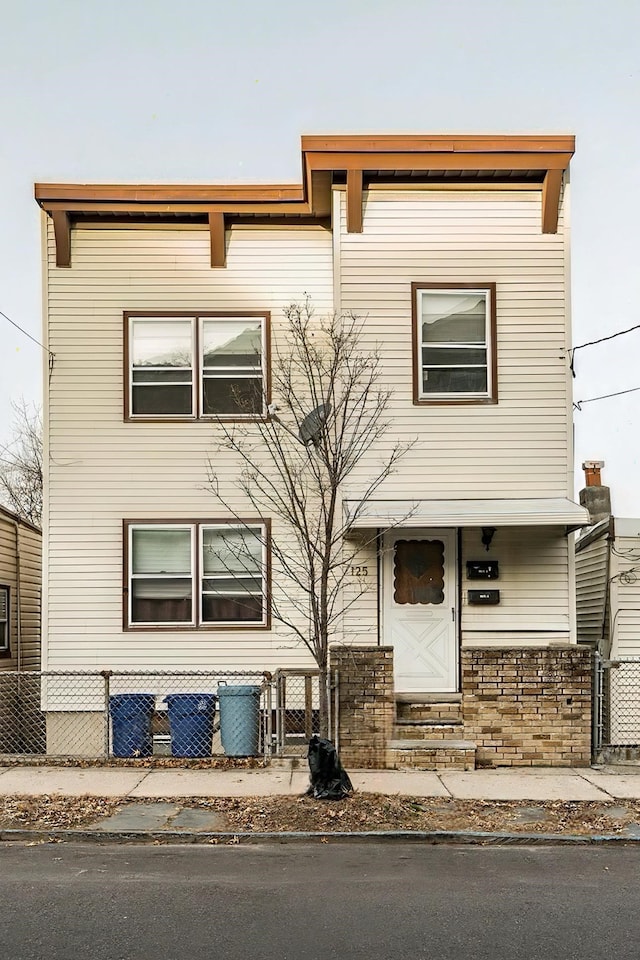 view of front facade featuring entry steps and a fenced front yard