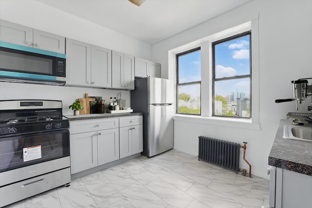 1204 Central Ave Unit 4C, Union City, NJ 07087 - kitchen with stainless steel appliances, radiator heating unit, light marble finish floors, and dark countertops