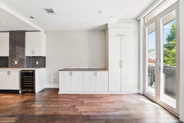 interior space featuring visible vents, dark wood finished floors, wine cooler, and white cabinetry