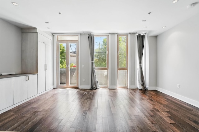 spare room with recessed lighting, baseboards, and dark wood-type flooring