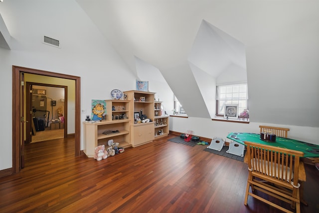 playroom with dark wood finished floors, visible vents, baseboards, and vaulted ceiling