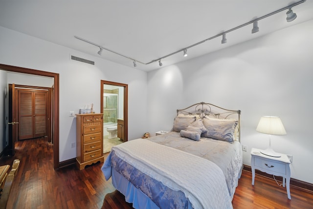 bedroom with visible vents, wood finished floors, and track lighting