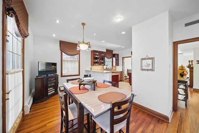 dining area with visible vents, baseboards, baseboard heating, recessed lighting, and wood finished floors