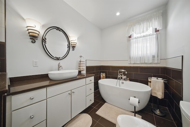 full bathroom featuring tile patterned flooring, toilet, vanity, and a freestanding tub