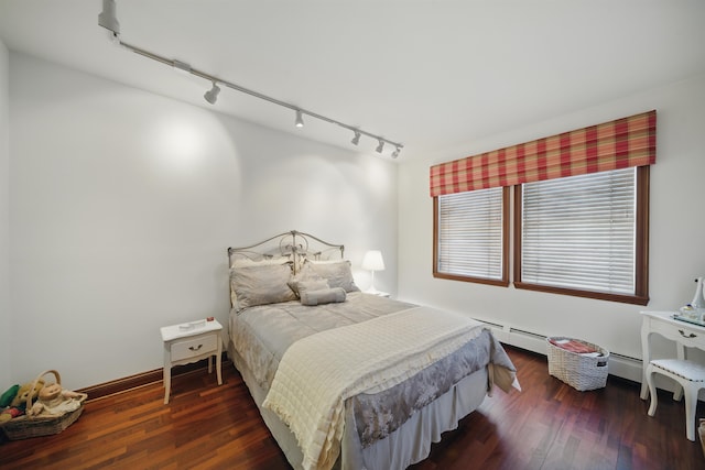 bedroom with a baseboard heating unit, baseboards, and wood finished floors