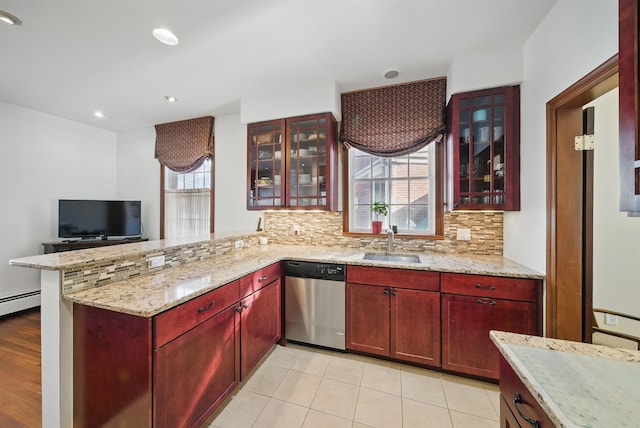 kitchen featuring dark brown cabinets, dishwasher, a peninsula, and a sink