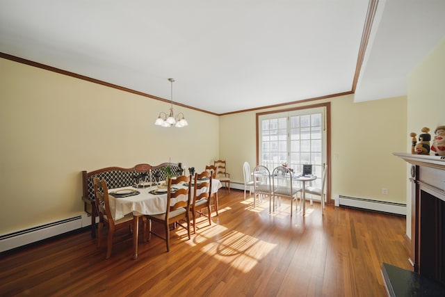 dining space with a baseboard radiator, wood finished floors, a fireplace, and ornamental molding