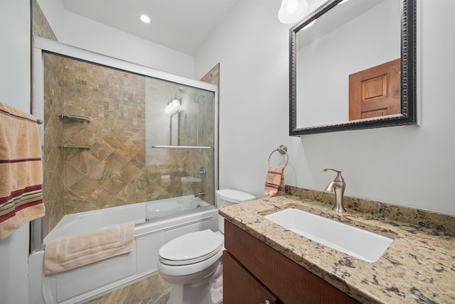 bathroom with combined bath / shower with glass door, toilet, and vanity