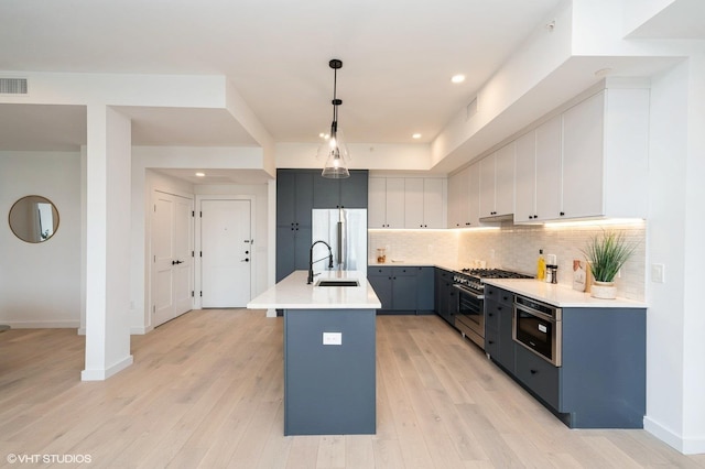 425 3rd St Unit 404, Jersey City, NJ 07302 - kitchen with appliances with stainless steel finishes, backsplash, light wood-style floors, light countertops, and pendant lighting