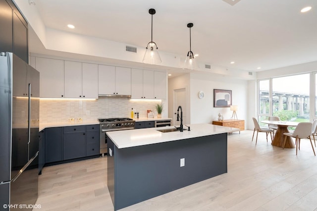 425 3rd St Unit 404, Jersey City, NJ 07302 - kitchen with premium appliances, light wood finished floors, light countertops, decorative backsplash, and decorative light fixtures