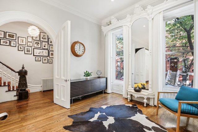 interior space with radiator, hardwood / wood-style flooring, and ornamental molding