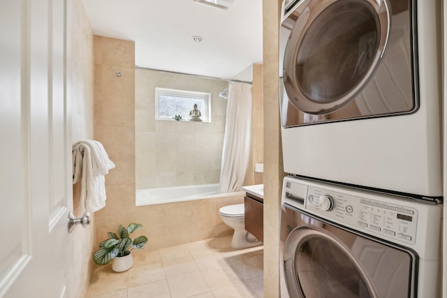 washroom with light tile patterned floors and stacked washer / dryer