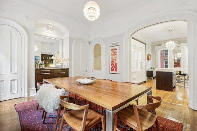 dining space featuring light hardwood / wood-style flooring and ornamental molding