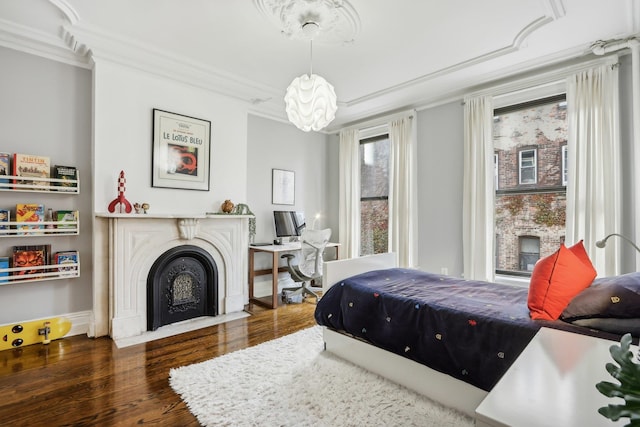 bedroom featuring dark hardwood / wood-style flooring, a notable chandelier, and crown molding