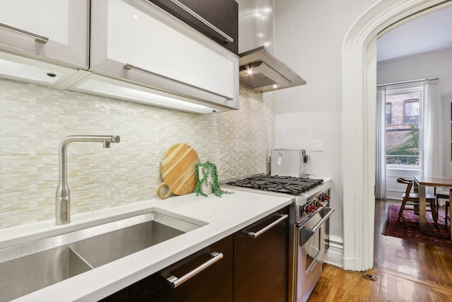 kitchen with island exhaust hood, dark brown cabinets, sink, dark wood-type flooring, and high end range