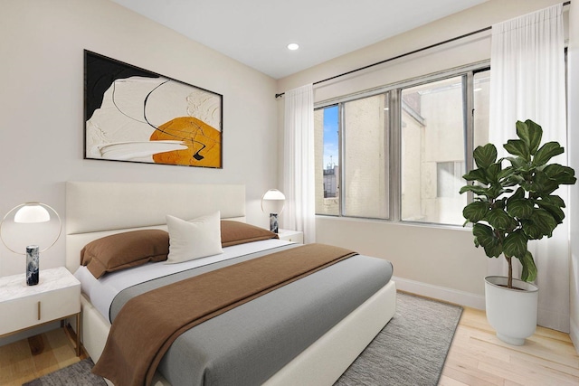 bedroom featuring baseboards, recessed lighting, and wood finished floors