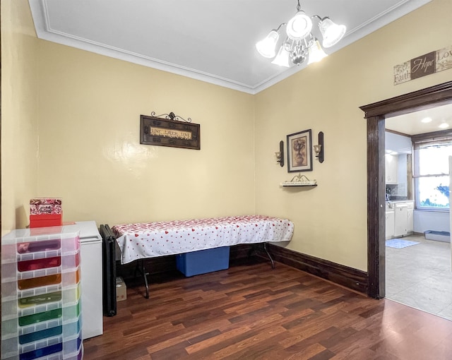 bedroom featuring a notable chandelier, ornamental molding, and dark hardwood / wood-style floors