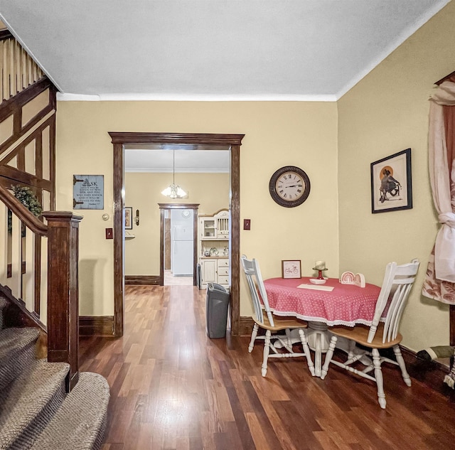 dining area with a notable chandelier, hardwood / wood-style flooring, and ornamental molding