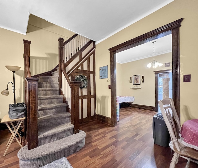 stairs featuring ornamental molding, hardwood / wood-style floors, and a notable chandelier