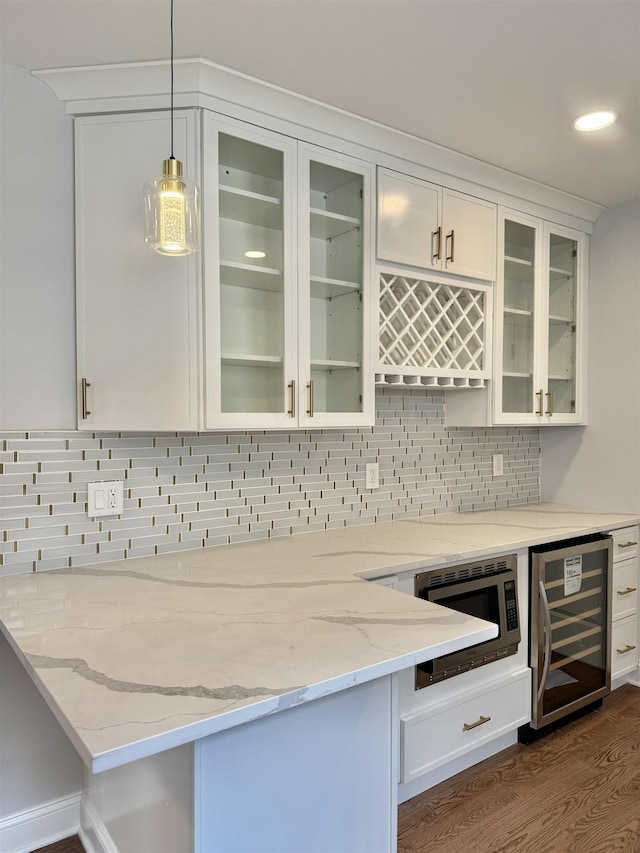 3 Raydol Ave, Secaucus, NJ 07094 - indoor dry bar with beverage cooler, stainless steel microwave, pendant lighting, dark wood-type flooring, and tasteful backsplash