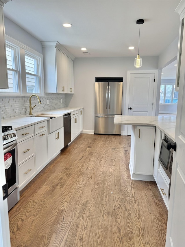3 Raydol Ave, Secaucus, NJ 07094 - kitchen with stainless steel appliances, light wood-style floors, tasteful backsplash, recessed lighting, and white cabinetry