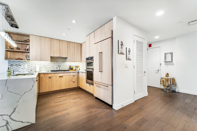 kitchen with tasteful backsplash, stainless steel appliances, dark hardwood / wood-style floors, light brown cabinets, and light stone countertops