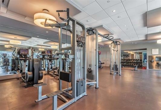 gym with a paneled ceiling and concrete floors