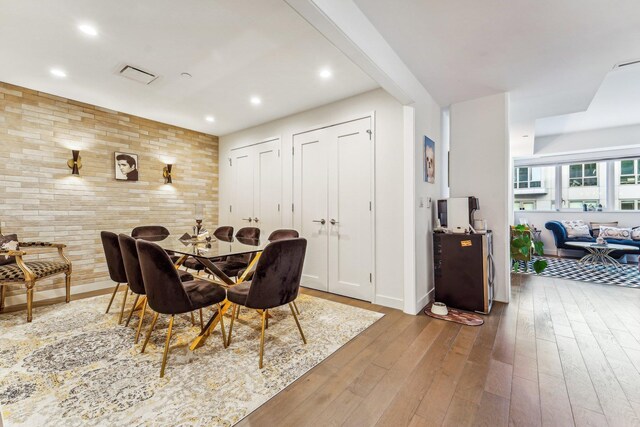 kitchen featuring stainless steel appliances, light stone counters, light brown cabinets, light hardwood / wood-style flooring, and pendant lighting