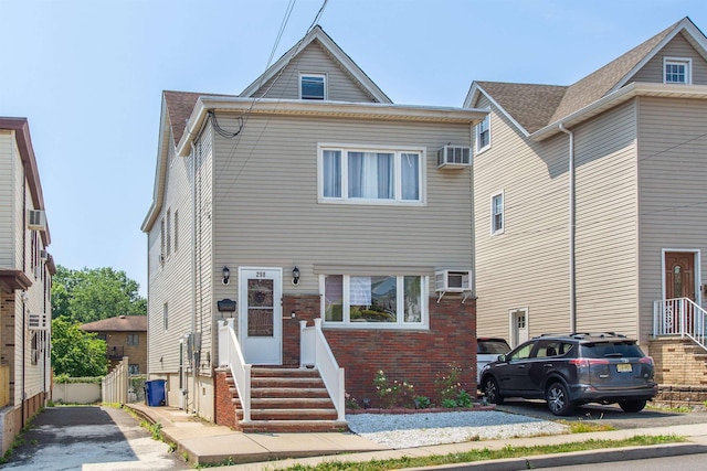 multi unit property with brick siding and a wall mounted AC