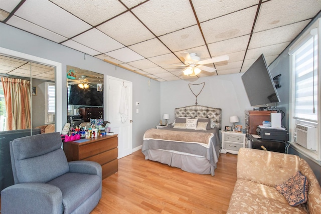 bedroom featuring light wood-style floors and a drop ceiling