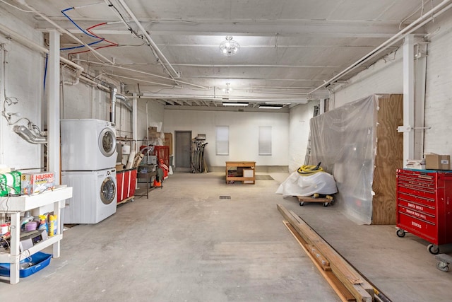 basement featuring stacked washer and clothes dryer