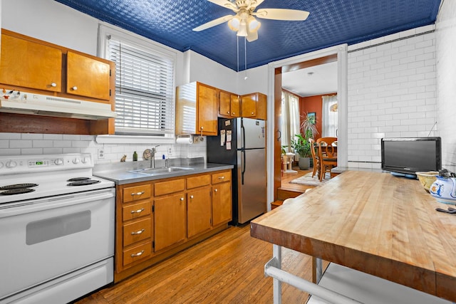 kitchen with sink, ceiling fan, light hardwood / wood-style flooring, stainless steel fridge, and white electric range