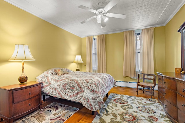 bedroom featuring a baseboard radiator, ceiling fan, ornamental molding, and light hardwood / wood-style flooring