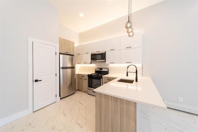 481 Martin Luther King Jr Dr, Jersey City, NJ 07304 - kitchen with a peninsula, light countertops, appliances with stainless steel finishes, marble finish floor, and a sink